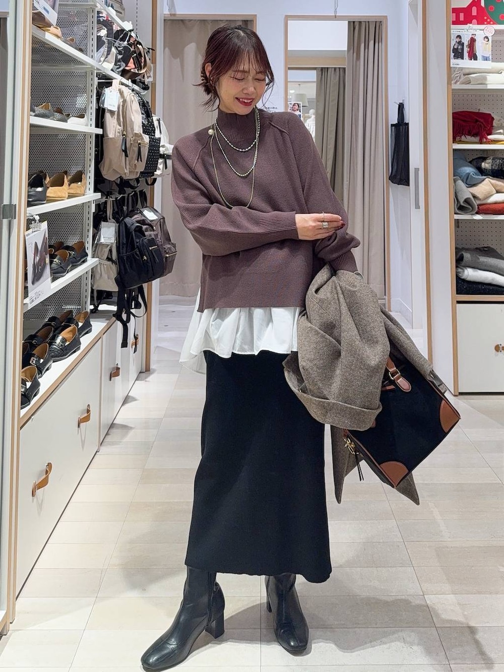 ブラウン系のチェスターコート、ホワイト系のTシャツ/カットソー、ブラウン系のニット/セーターを着用したレディースの冬コーディネートの3枚目の写真