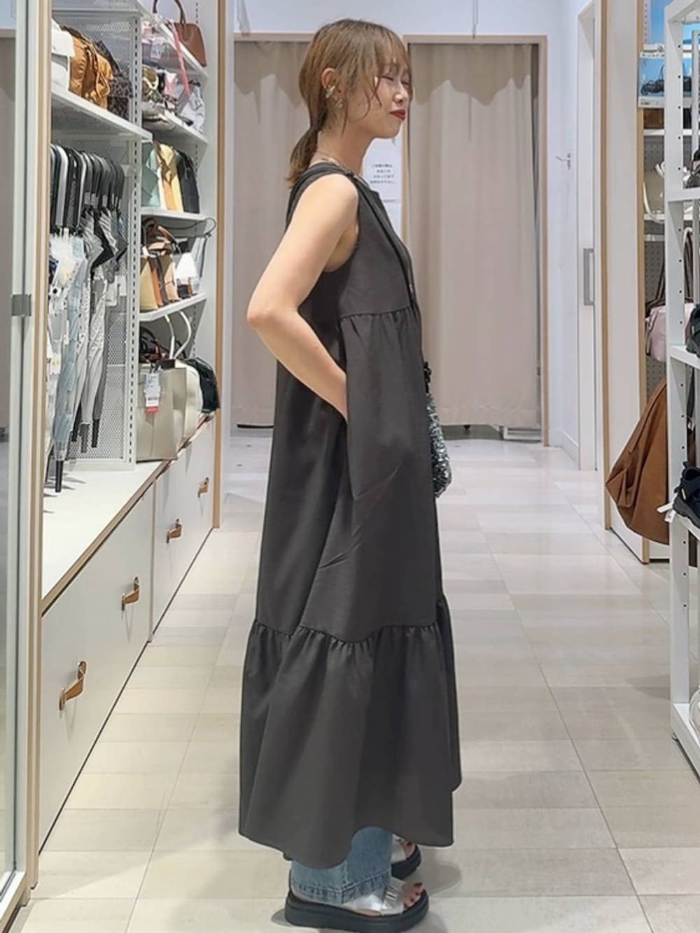 ブルー系のデニムパンツ、グレー系のワンピース、ブラウン系のTシャツ/カットソーを着用したレディースの夏コーディネートの6枚目の写真