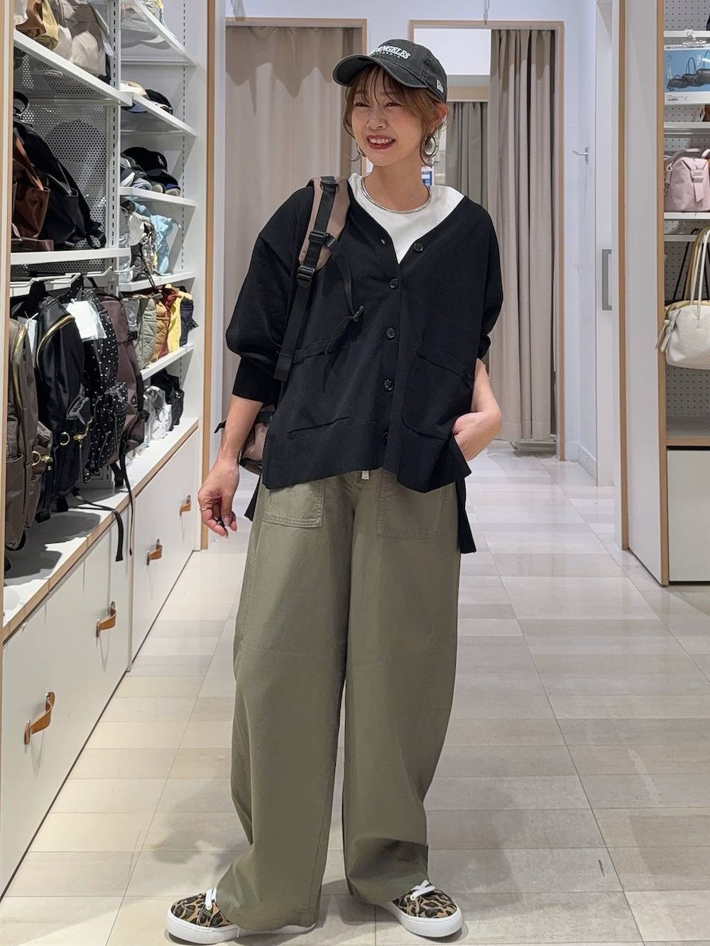 グリーン系のその他パンツ、その他のスニーカー、ブラック系のカーディガン/ボレロを着用したレディースの春コーディネートの2枚目の写真
