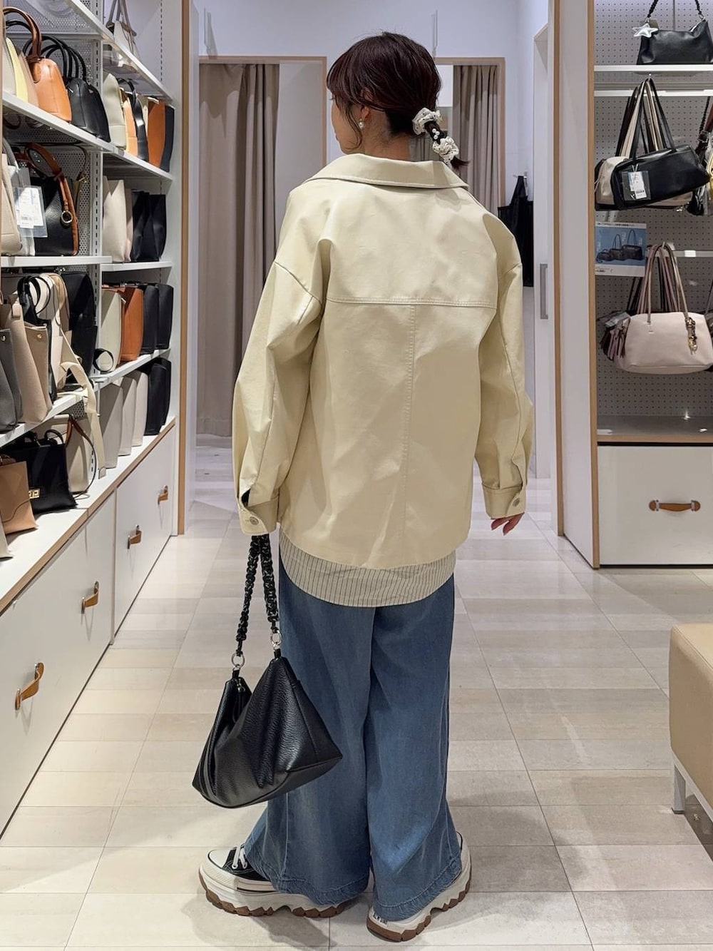 ホワイト系のブルゾン、ホワイト系のニット/セーター、イエロー系のカーディガン/ボレロを着用したレディースの春コーディネートの6枚目の写真