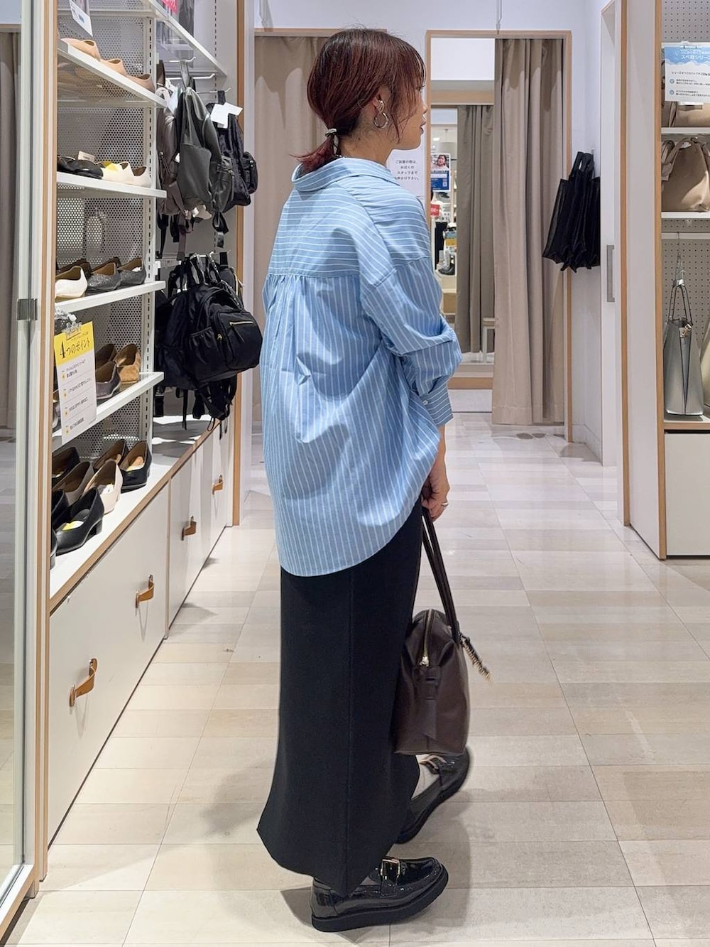 ブラック系のローファー、ブラウン系のボストンバッグ、ブラック系のスウェットを着用したレディースの秋コーディネートの6枚目の写真