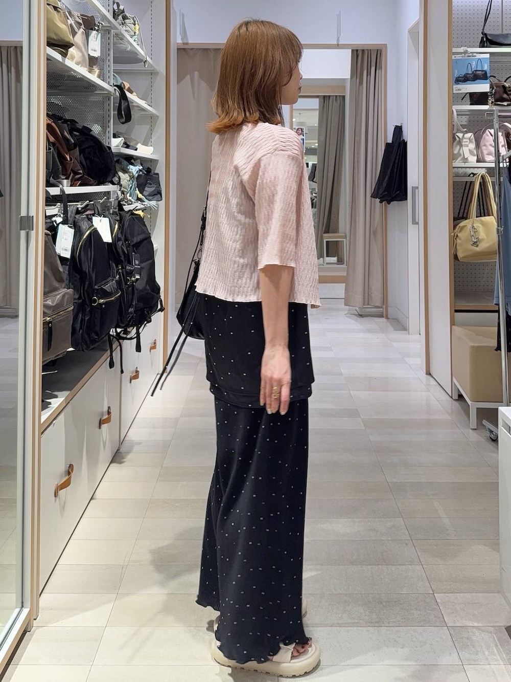 ホワイト系のキャミソール、ブルー系のデニムパンツ、ブラック系のニット/セーターを着用したレディースの春コーディネートの6枚目の写真