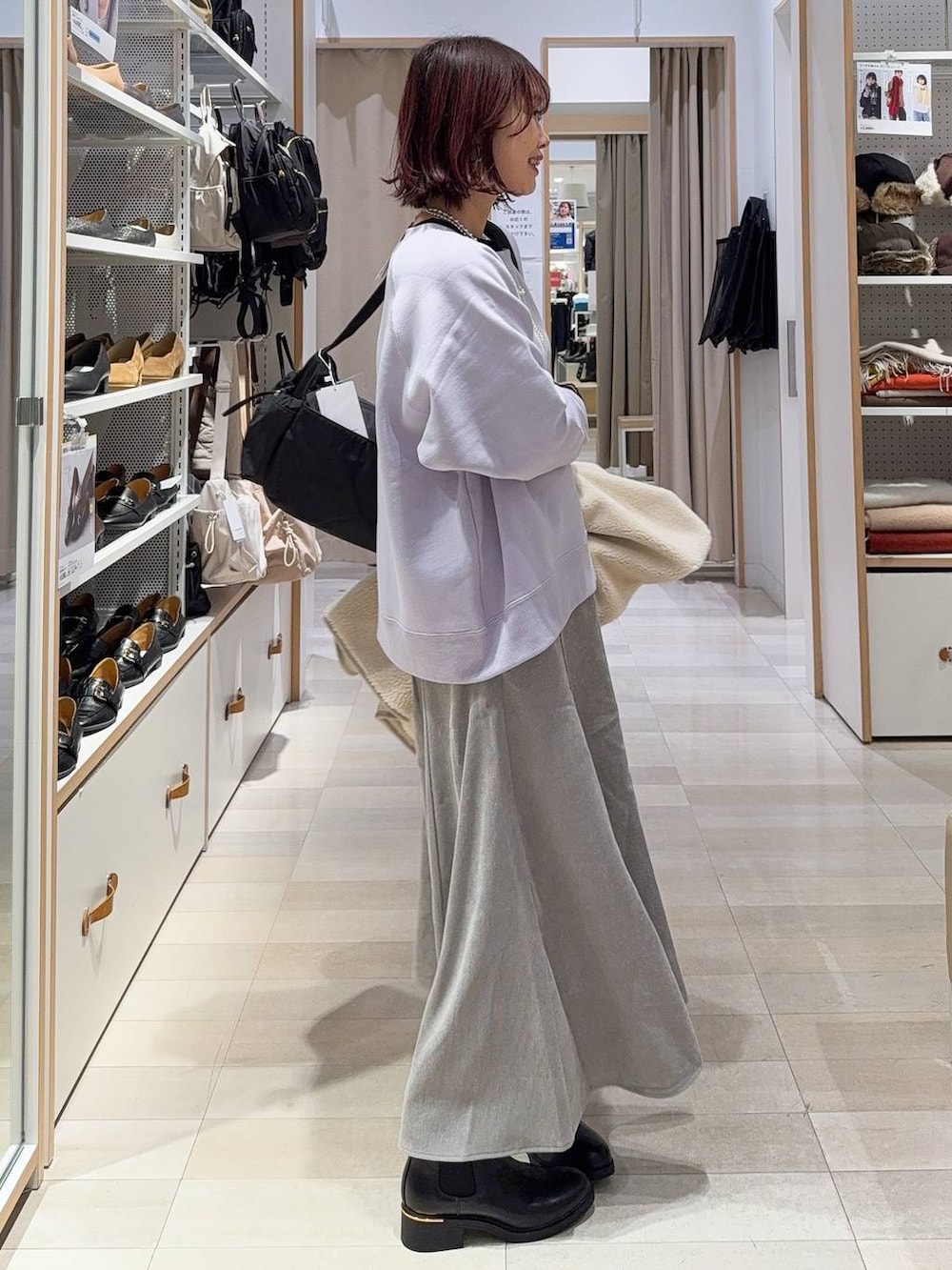 ブラック系のショルダーバッグ、グレー系のスカート、パープル系のスウェットを着用したレディースの冬コーディネートの5枚目の写真