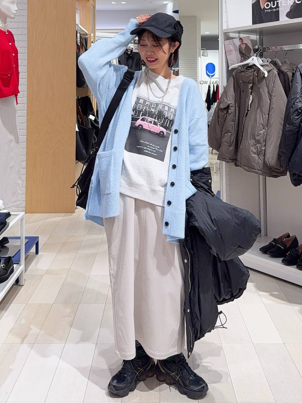 ブラック系のトートバッグ、ブルー系のカーディガン/ボレロ、グレー系のスカートを着用したレディースの秋コーディネートの2枚目の写真