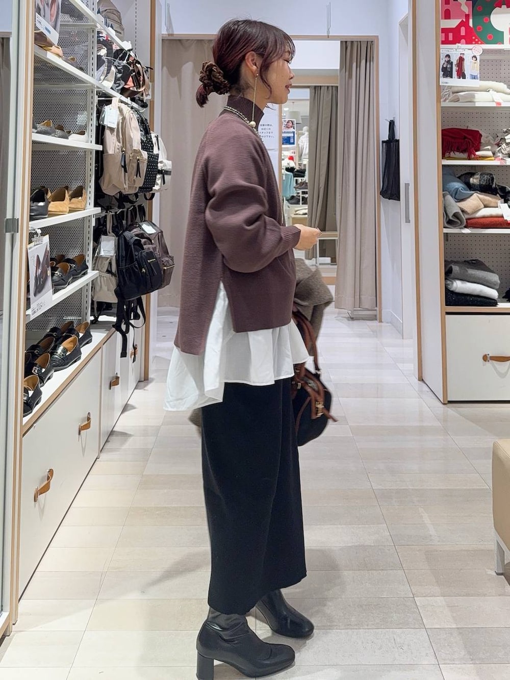 ブラウン系のチェスターコート、ホワイト系のTシャツ/カットソー、ブラウン系のニット/セーターを着用したレディースの冬コーディネートの7枚目の写真