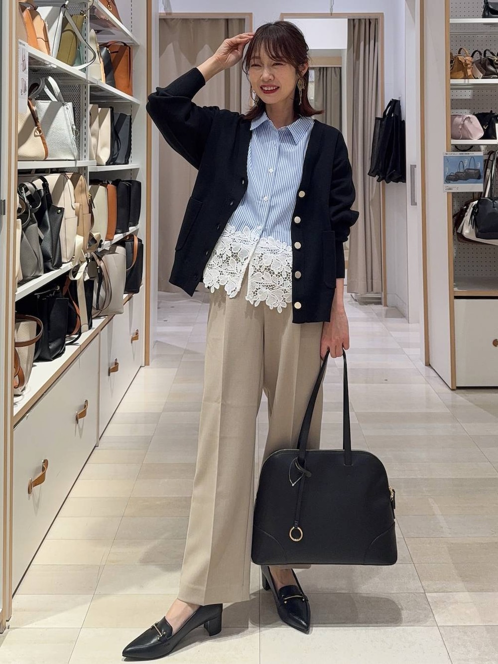 ベージュ系のその他パンツ、ブラック系のカーディガン/ボレロ、ブラック系のボストンバッグを着用したレディースの春コーディネートの2枚目の写真