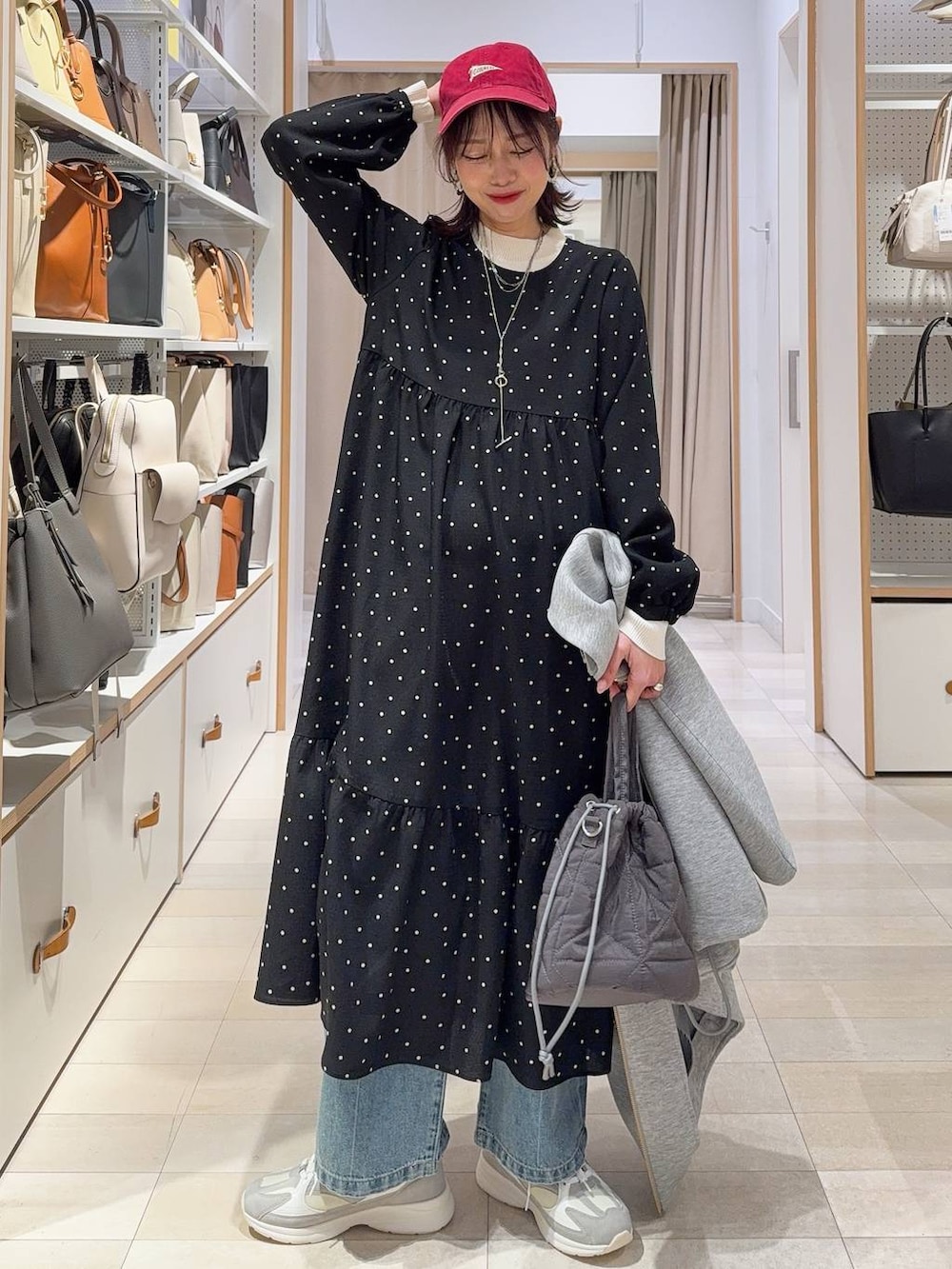 ホワイト系のスニーカー、ブルー系のデニムパンツ、ホワイト系のニット/セーターを着用したレディースの冬コーディネートの2枚目の写真