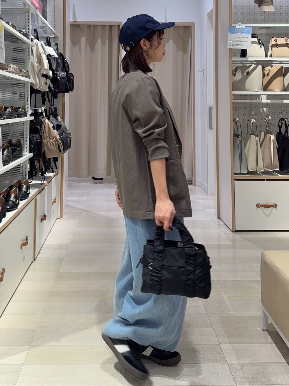 ブラック系のスニーカー、ブラック系のショルダーバッグ、ホワイト系のTシャツ/カットソーを着用したレディースの秋コーディネートの4枚目の写真