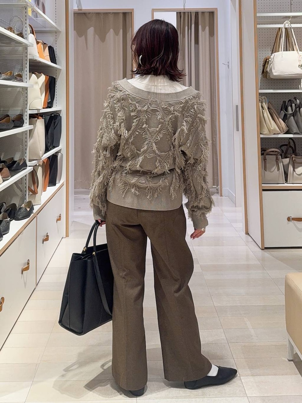 ブラック系のパンプス、ホワイト系のニット/セーター、ブラウン系のその他パンツを着用したレディースの冬コーディネートの6枚目の写真