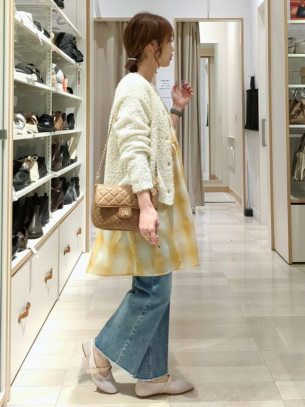 ブルー系のデニムパンツ、ベージュ系のショルダーバッグ、ホワイト系のTシャツ/カットソーを着用したレディースの春コーディネートの4枚目の写真