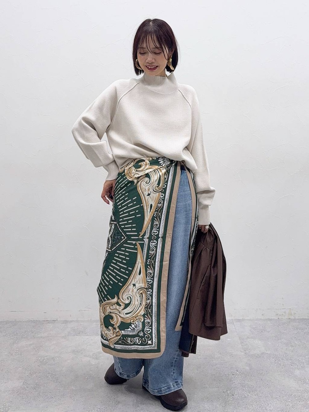 ブラウン系のバックパック/リュック、ブラウン系のスカート、ブラック系のブーツを着用したレディースの冬コーディネートの4枚目の写真