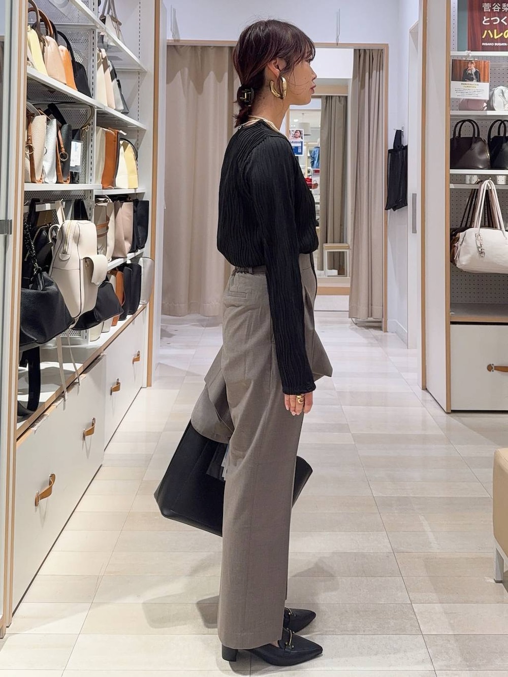 ブラウン系のスラックス、ブラック系のTシャツ/カットソー、ブラック系のトートバッグを着用したレディースの冬コーディネートの8枚目の写真