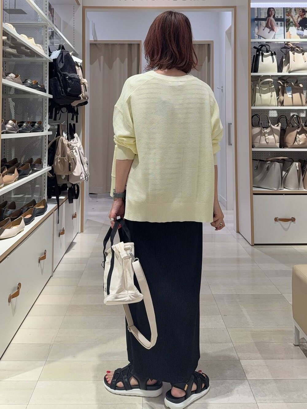 ブラック系のスカート、イエロー系のカーディガン/ボレロ、ホワイト系のトートバッグを着用したレディースの夏コーディネートの7枚目の写真