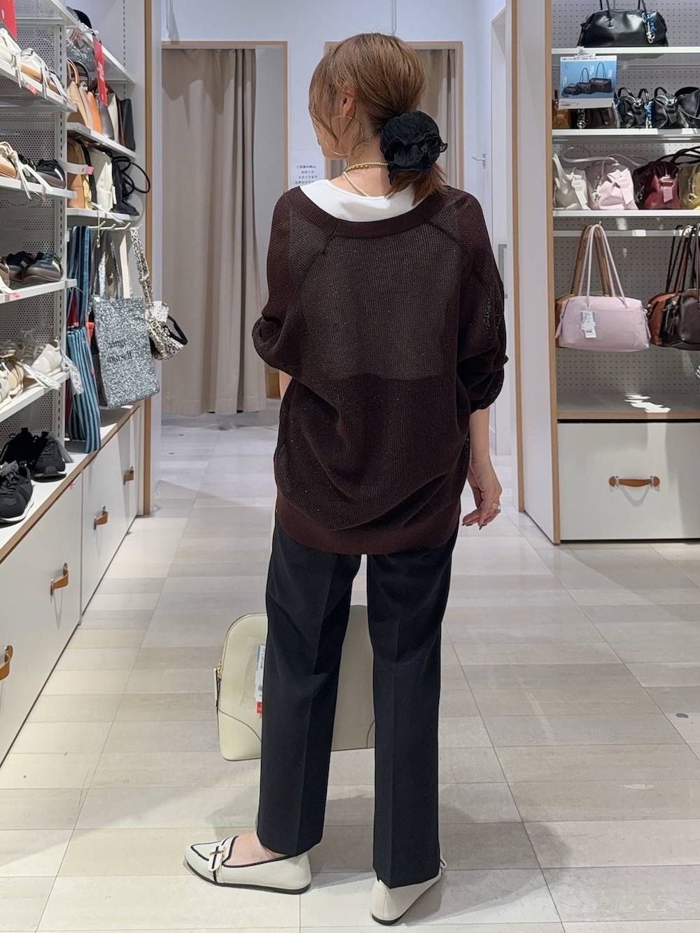 ホワイト系のパンプス、ベージュ系のボストンバッグ、ブラック系のその他パンツを着用したレディースの夏コーディネートの6枚目の写真