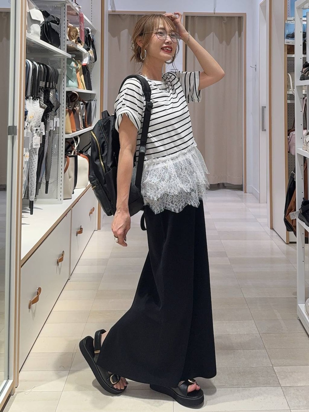 ブラック系のショルダーバッグ、ベージュ系のその他パンツ、ブラック系のサンダルを着用したレディースの夏コーディネートの2枚目の写真