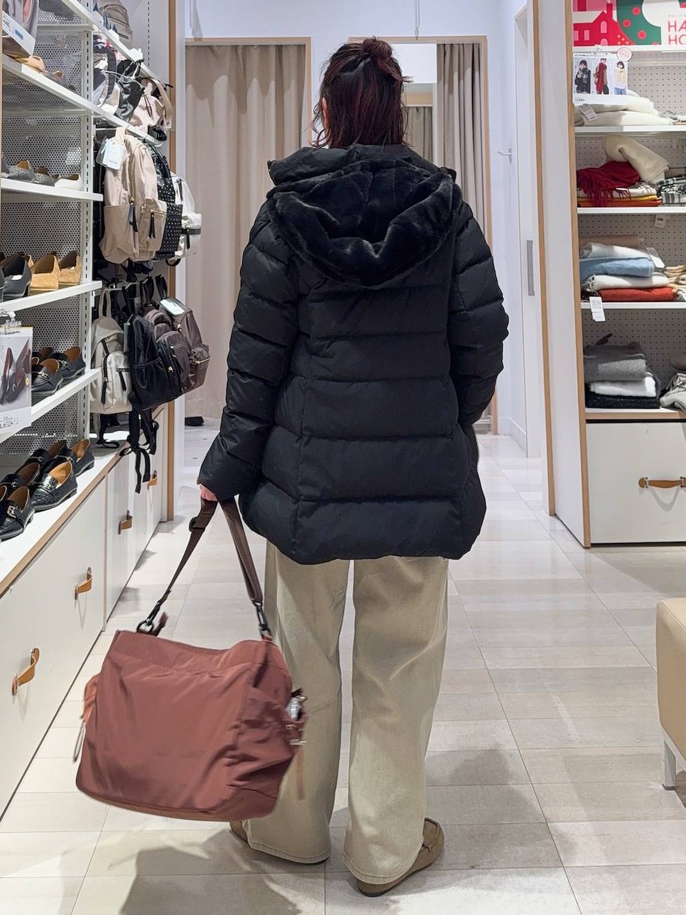 ブラック系のダウンジャケット/コート、ベージュ系のデニムパンツ、ホワイト系のTシャツ/カットソーを着用したレディースの冬コーディネートの5枚目の写真