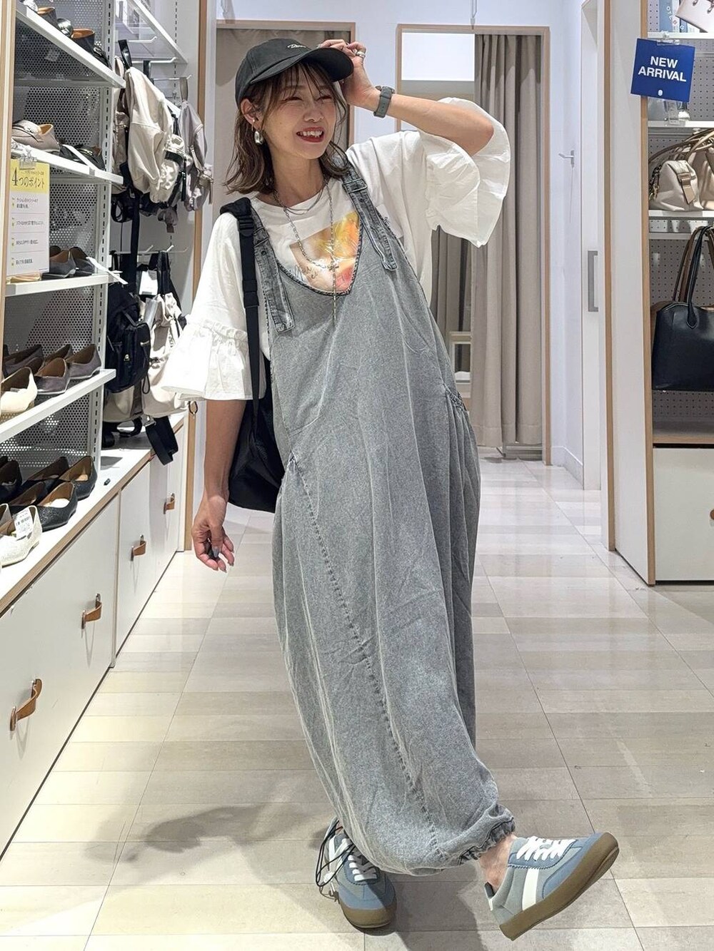 ブラウン系のサンダル、ブラウン系のデニムパンツ、ブラック系のハンドバッグを着用したレディースの夏コーディネートの2枚目の写真