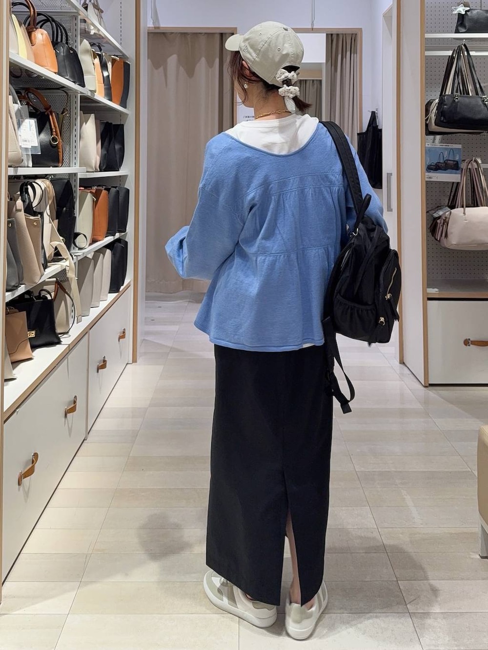 グレー系のスニーカー、ブラック系のバックパック/リュック、ブラック系のスカートを着用したレディースの春コーディネートの5枚目の写真