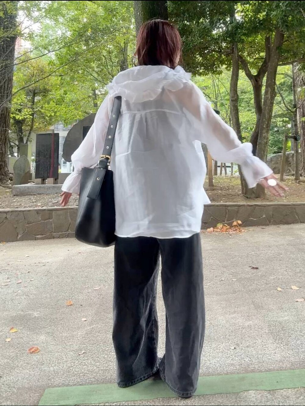 ブラック系のショルダーバッグ、ブラック系のキャミソール、ホワイト系のシャツ/ブラウスを着用したレディースの秋コーディネートの4枚目の写真