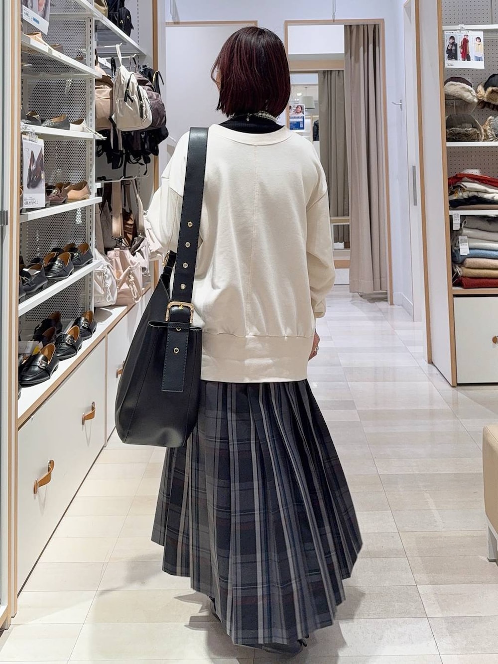 ブラック系のショルダーバッグ、ブラック系のニット/セーター、ブラック系のその他アウターを着用したレディースの秋コーディネートの9枚目の写真