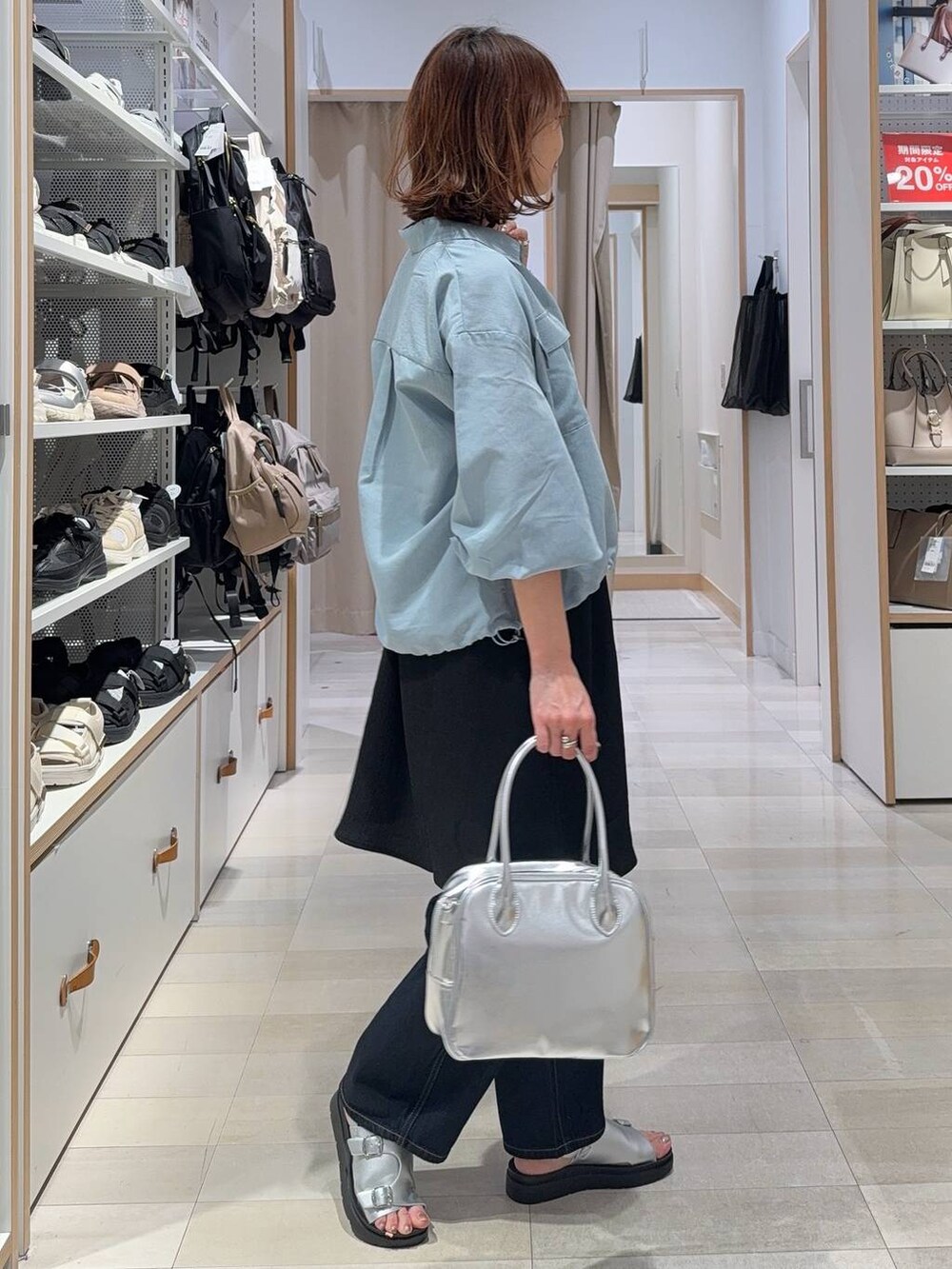 ブルー系のデニムパンツ、グレー系のボストンバッグ、ブルー系のシャツ/ブラウスを着用したレディースの春コーディネートの3枚目の写真