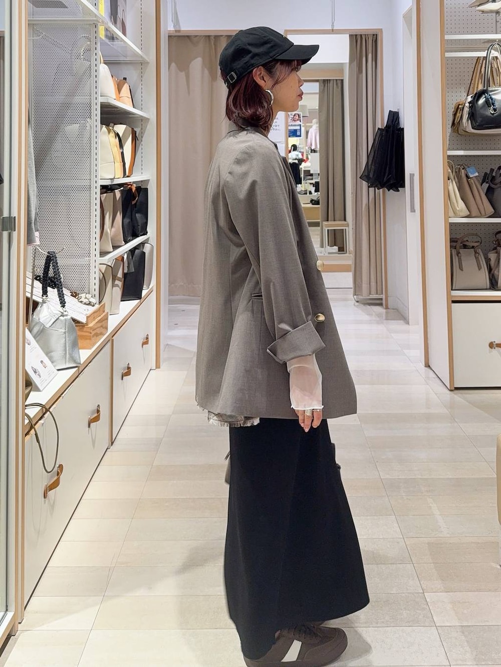 ブラウン系のスニーカー、ブラウン系のボストンバッグ、ブラウン系のテーラードジャケットを着用したレディースの冬コーディネートの5枚目の写真