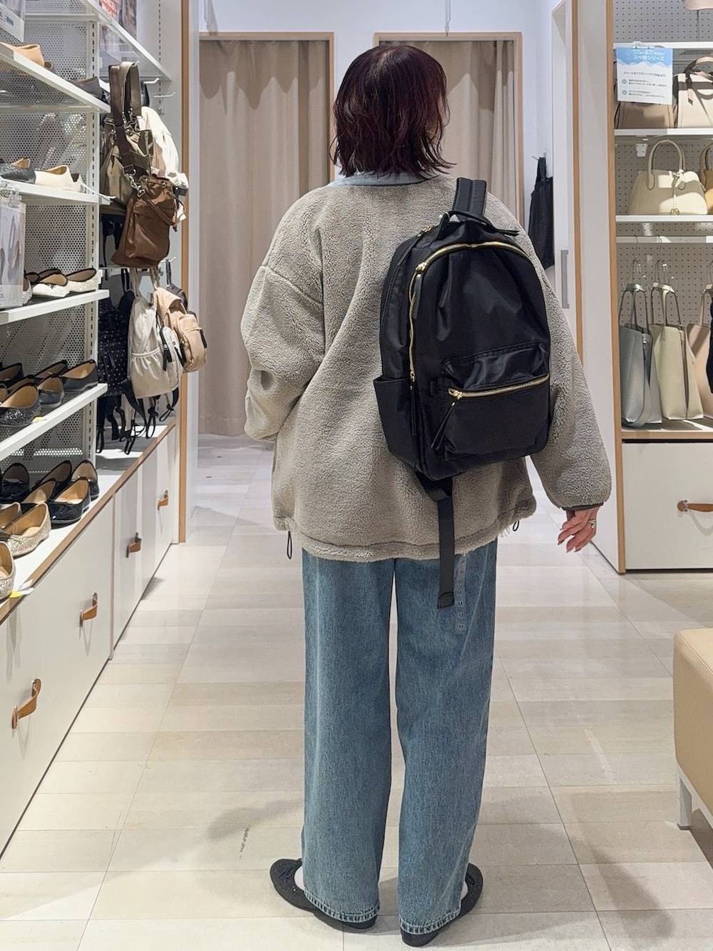 ブラック系のバレエシューズ、グレー系のブルゾン、ブルー系のデニムパンツを着用したレディースの秋コーディネートの5枚目の写真