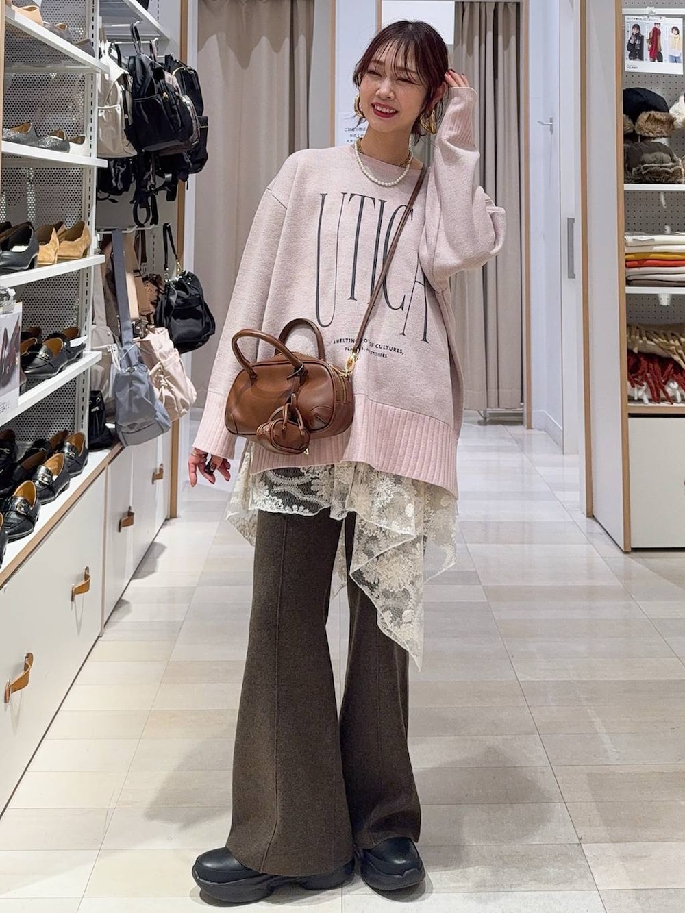 ブラック系のショルダーバッグ、ベージュ系のダウンジャケット/コート、ブラック系のその他パンツを着用したレディースの冬コーディネートの5枚目の写真