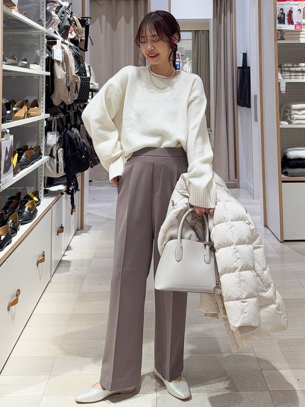 ホワイト系のブルゾン、ブルー系のデニムパンツ、ブラック系のバックパック/リュックを着用したレディースの冬コーディネートの4枚目の写真