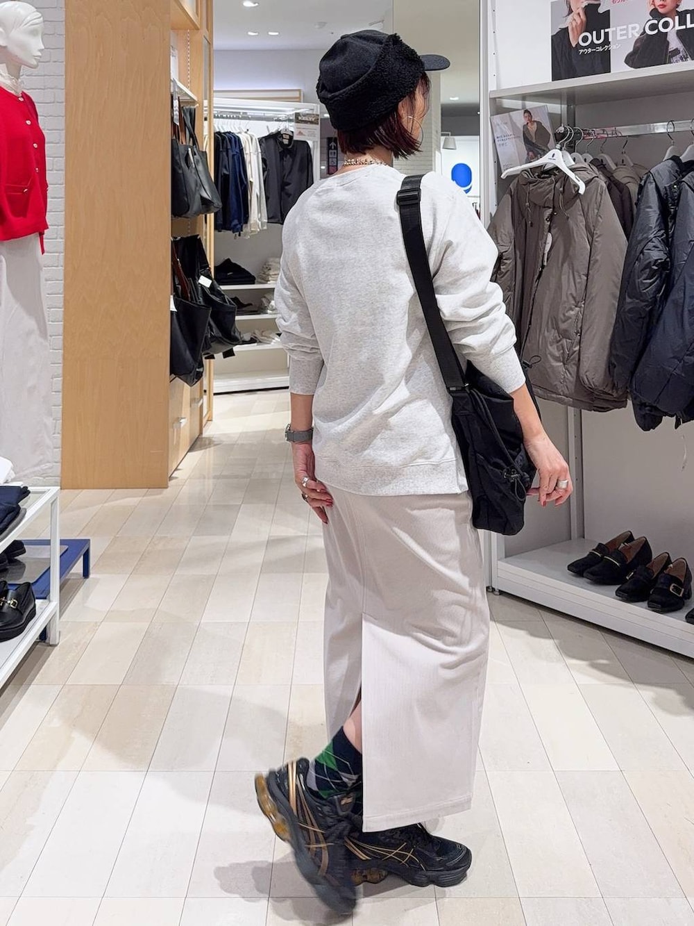 ブラック系のトートバッグ、ブルー系のカーディガン/ボレロ、グレー系のスカートを着用したレディースの秋コーディネートの8枚目の写真