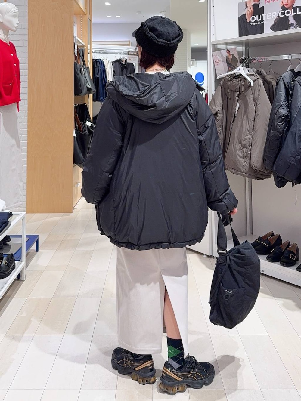 ブラック系のトートバッグ、ブルー系のカーディガン/ボレロ、グレー系のスカートを着用したレディースの秋コーディネートの5枚目の写真