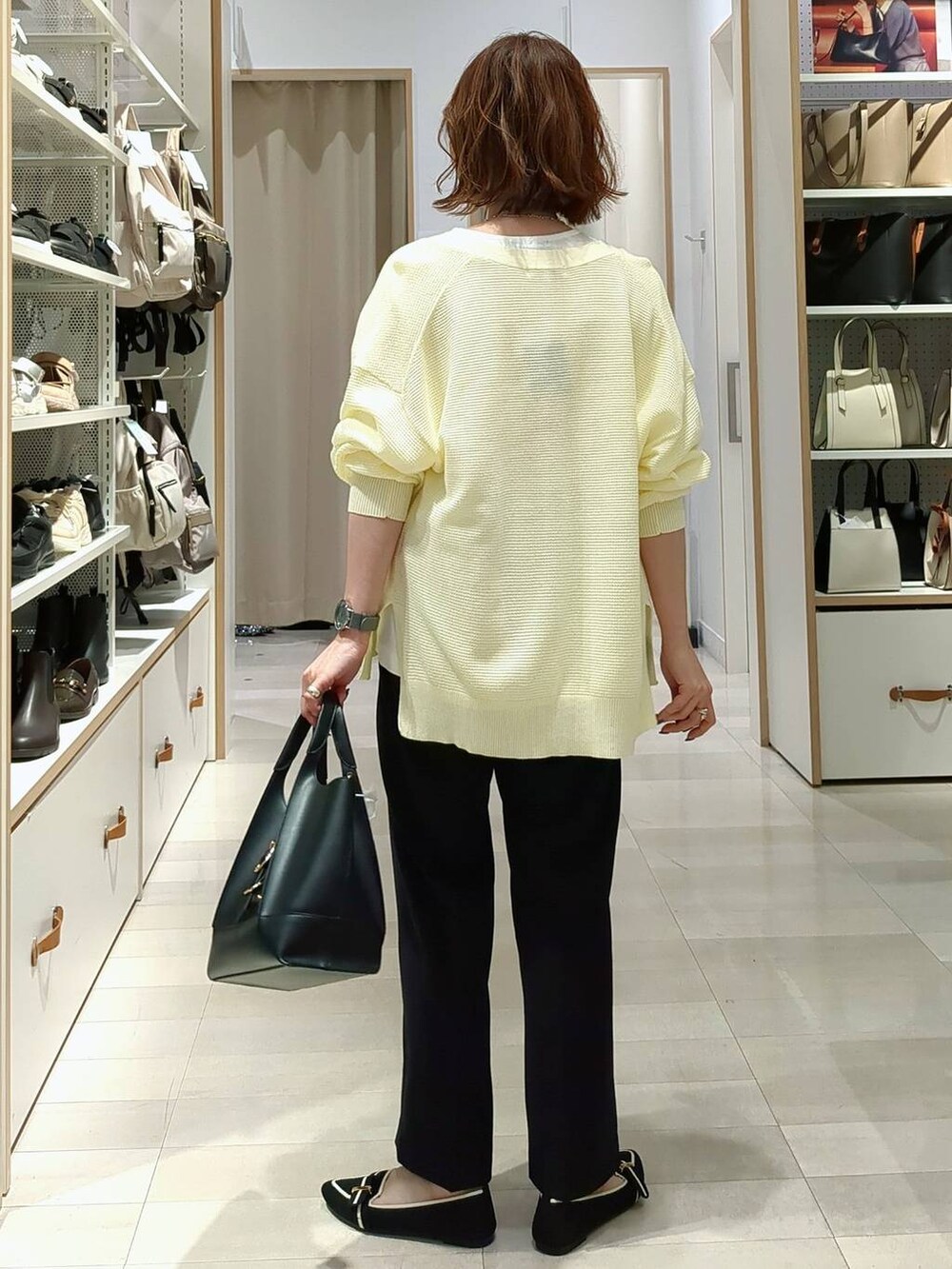 ブラック系のショルダーバッグ、イエロー系のカーディガン/ボレロ、その他のパンプスを着用したレディースの春コーディネートの5枚目の写真