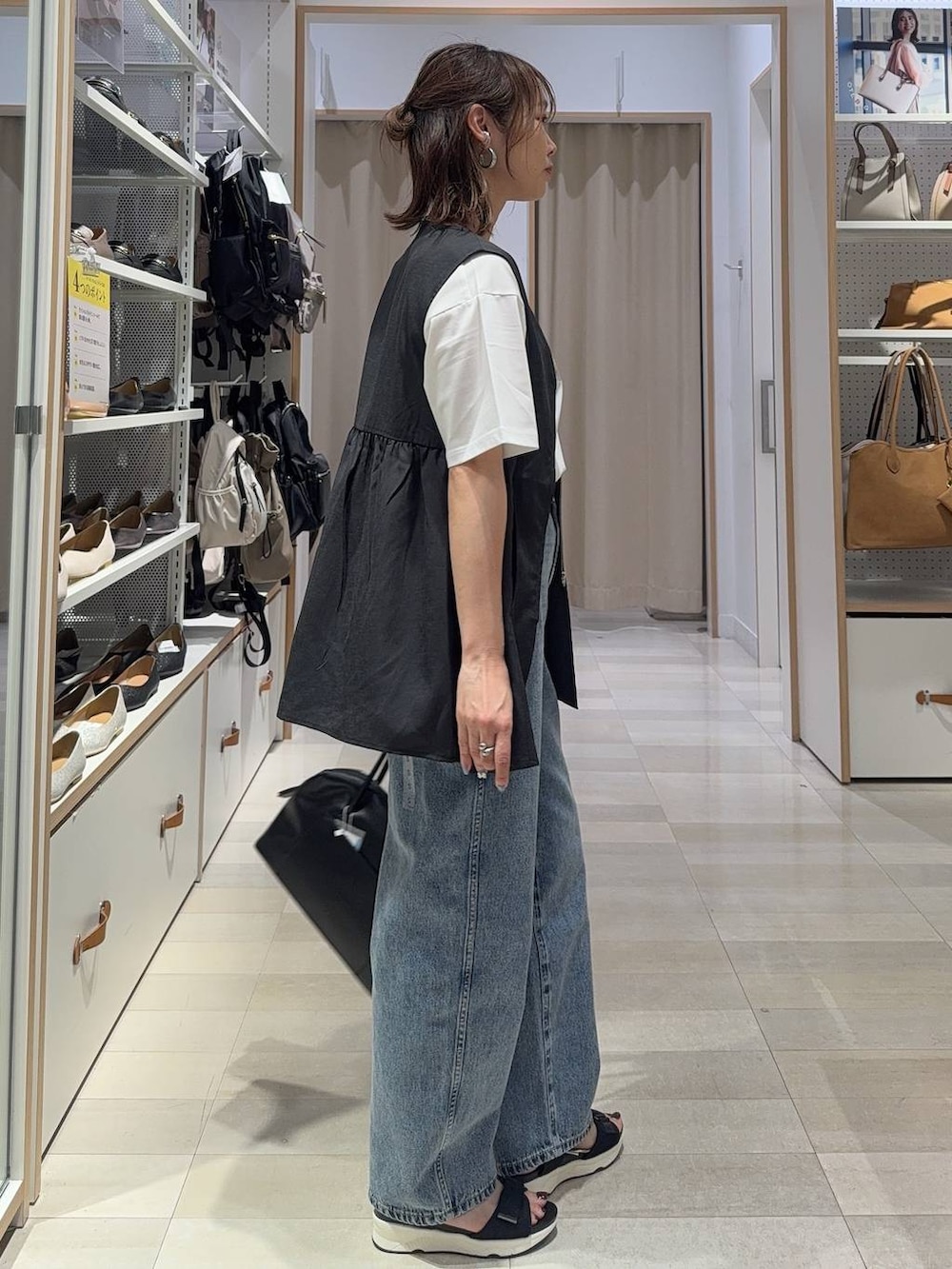 シルバー系のショルダーバッグ、ブラック系のTシャツ/カットソー、シルバー系のサンダルを着用したレディースの夏コーディネートの7枚目の写真