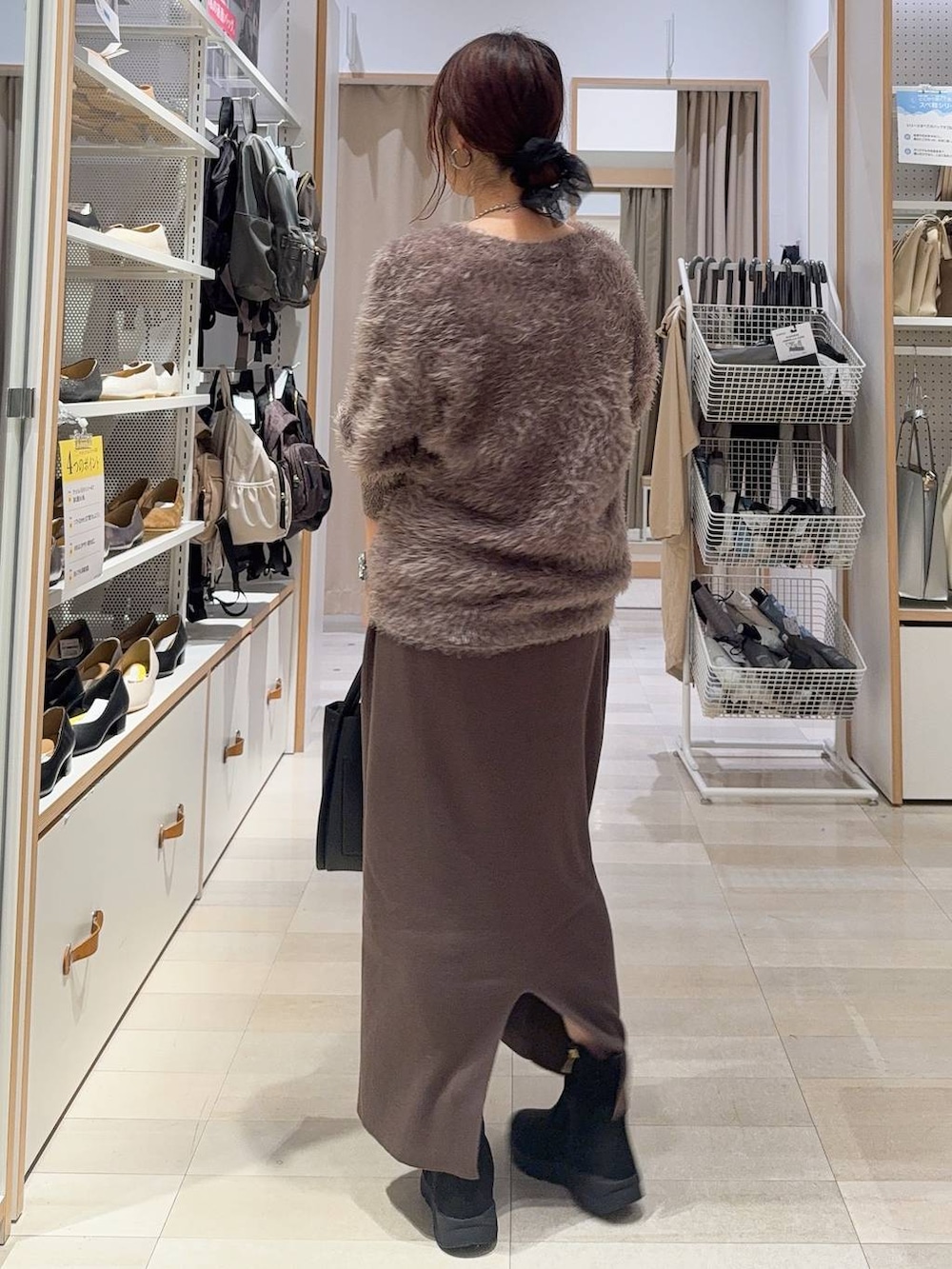 ブラック系のパンプス、ブラック系のボストンバッグ、ブルー系のデニムパンツを着用したレディースの秋コーディネートの7枚目の写真