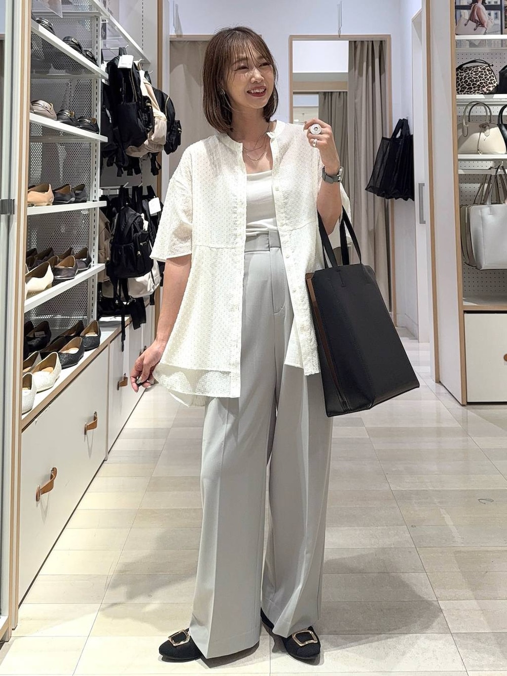 ホワイト系のショルダーバッグ、ブラック系のパンプス、ホワイト系のキャミソールを着用したレディースの夏コーディネートの2枚目の写真