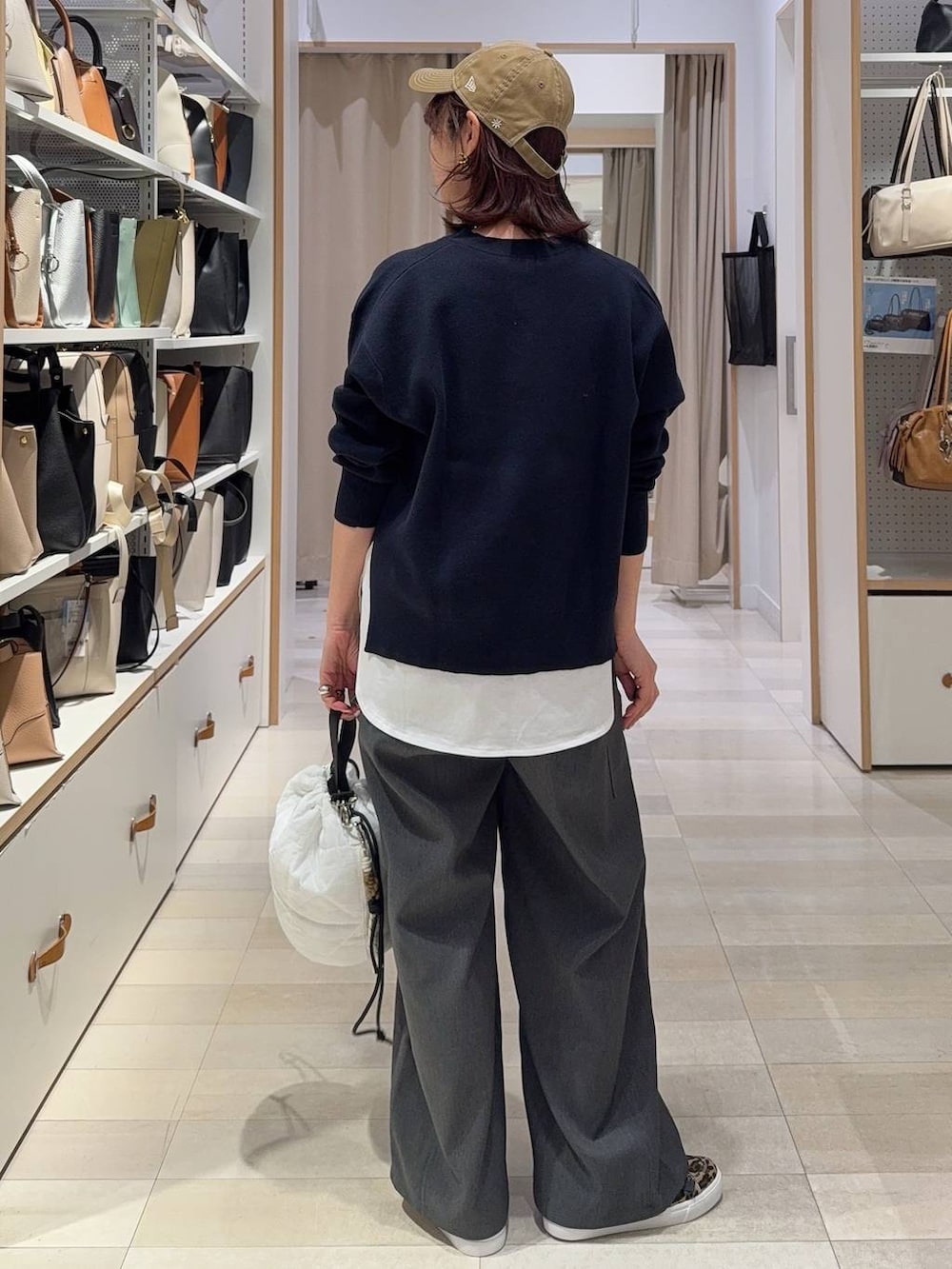 ホワイト系のハンドバッグ、ブルー系のニット/セーター、グレー系のその他パンツを着用したレディースの春コーディネートの5枚目の写真