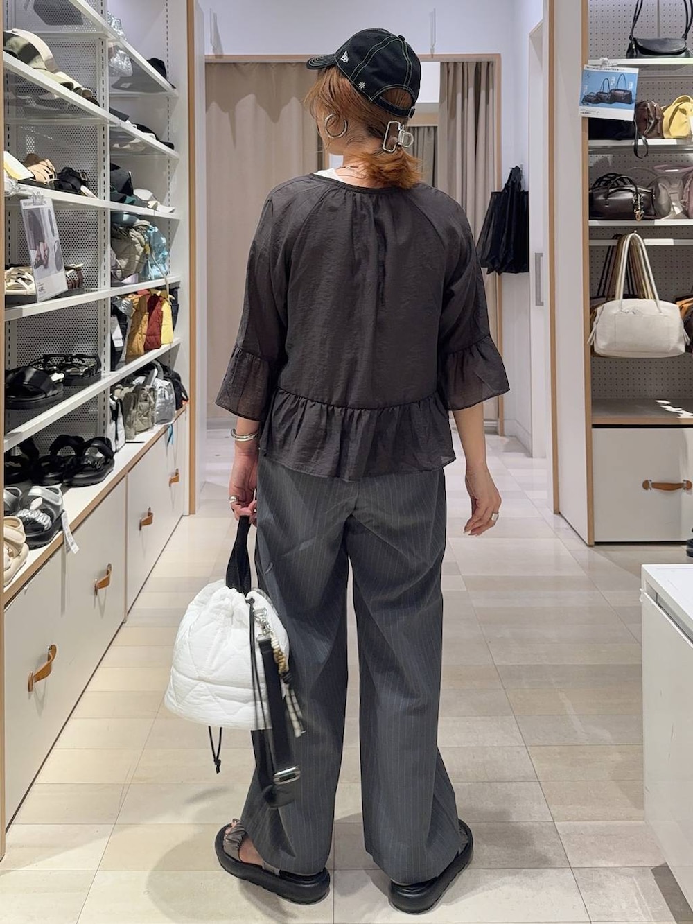 ホワイト系のハンドバッグ、グレー系のその他パンツ、その他のサンダルを着用したレディースの春コーディネートの7枚目の写真