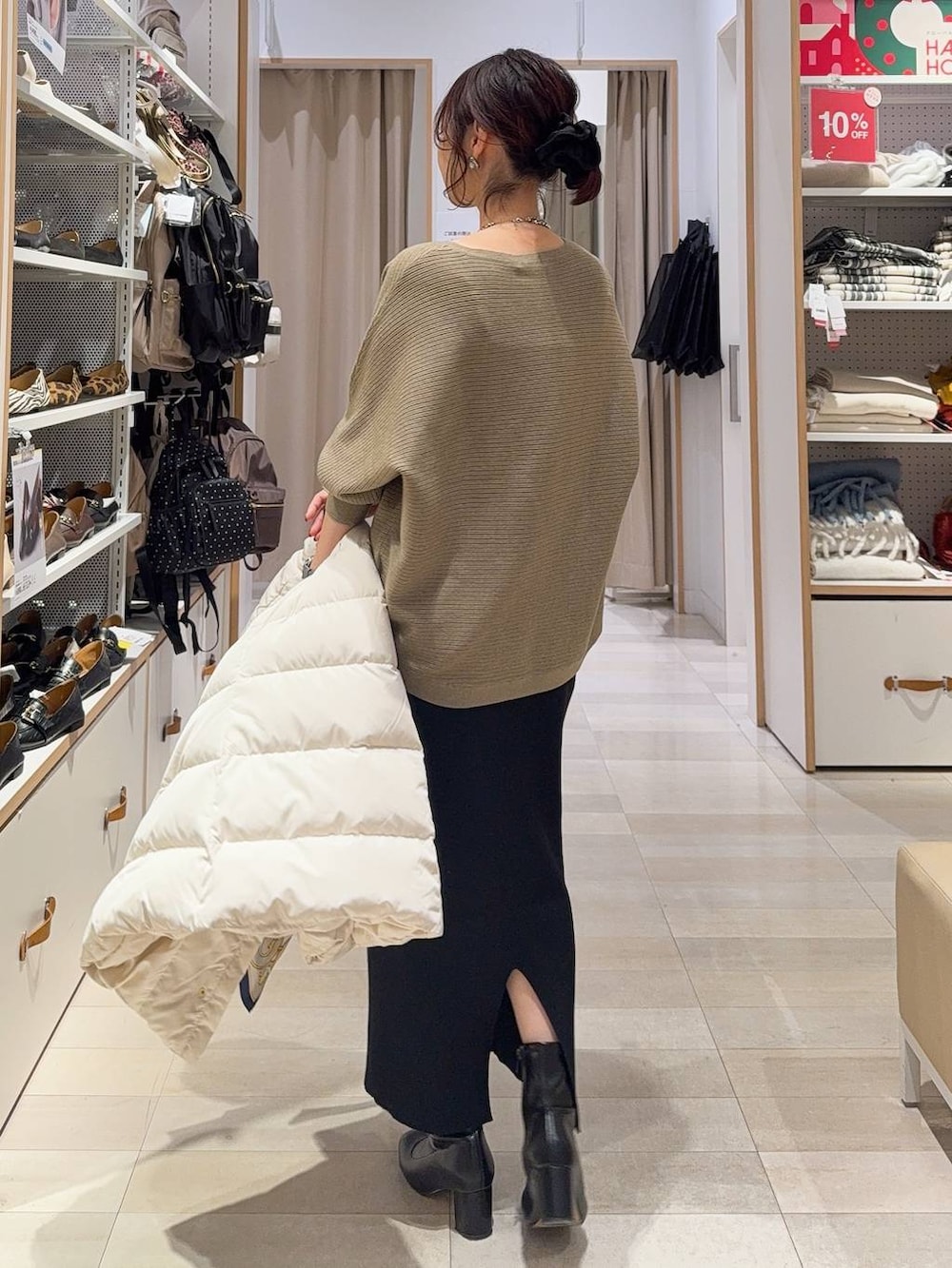 ベージュ系のダウンジャケット/コート、ブラック系のショルダーバッグ、ブラウン系のニット/セーターを着用したレディースの冬コーディネートの7枚目の写真