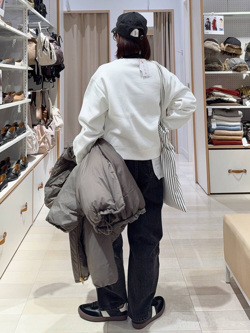 ブラック系のスニーカー、ブラウン系のダウンジャケット/コート、ブラック系のデニムパンツを着用したレディースの秋コーディネートの8枚目の写真