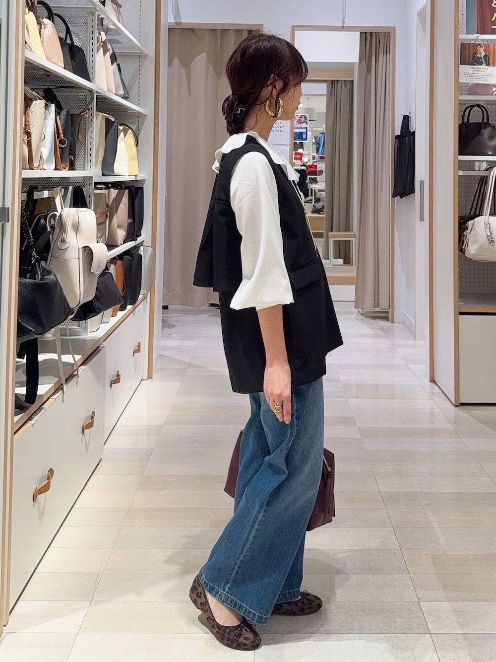 その他のバレエシューズ、レッド系のボストンバッグ、ブルー系のデニムパンツを着用したレディースの冬コーディネートの4枚目の写真