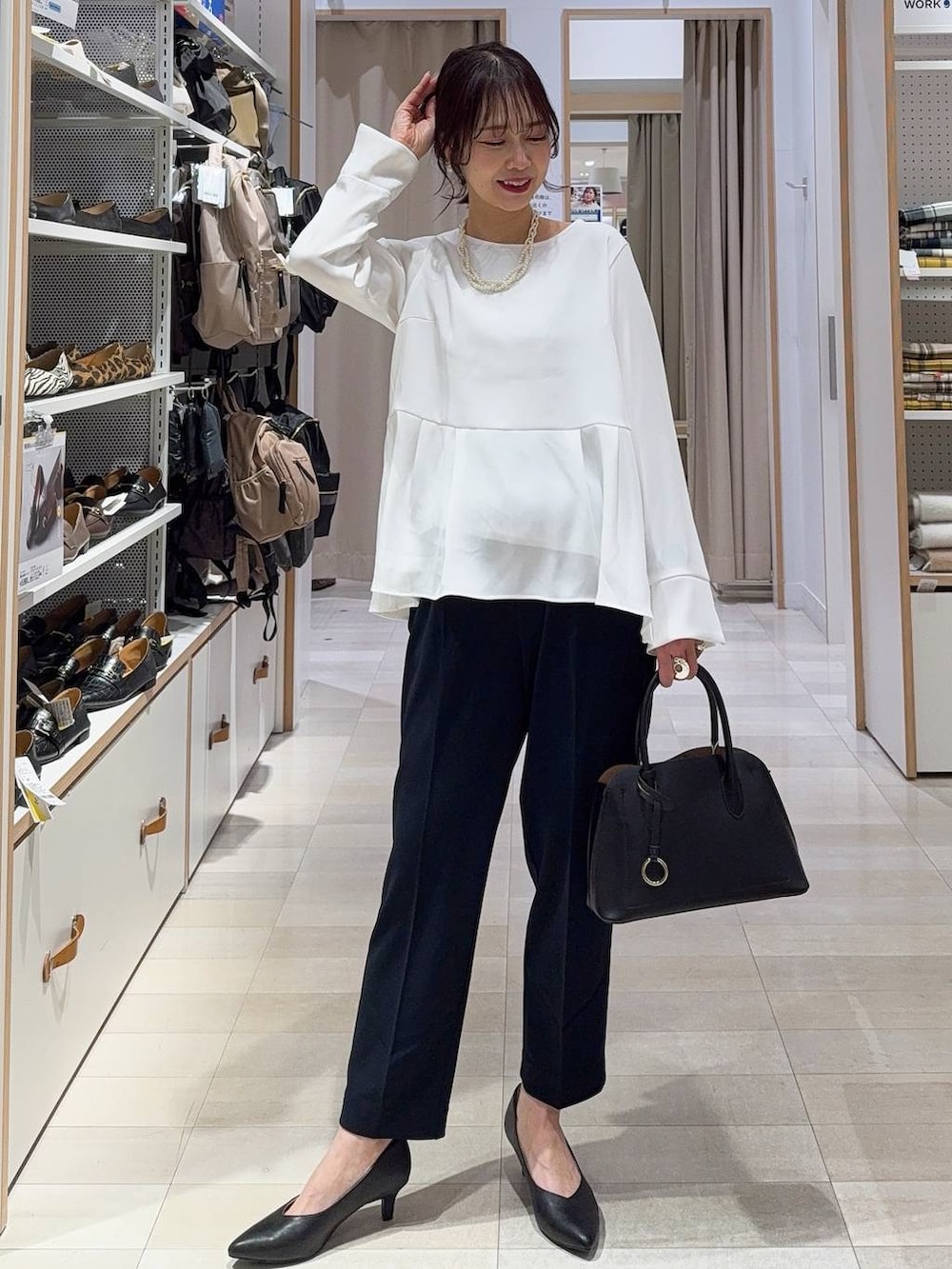 ブラック系のショルダーバッグ、ブラック系のパンプス、ブルー系のセットアップを着用したレディースの冬コーディネートの2枚目の写真