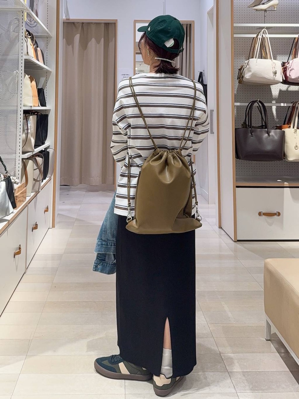 グリーン系のスニーカー、ブルー系のデニムジャケット、ブラック系のスカートを着用したレディースの冬コーディネートの8枚目の写真