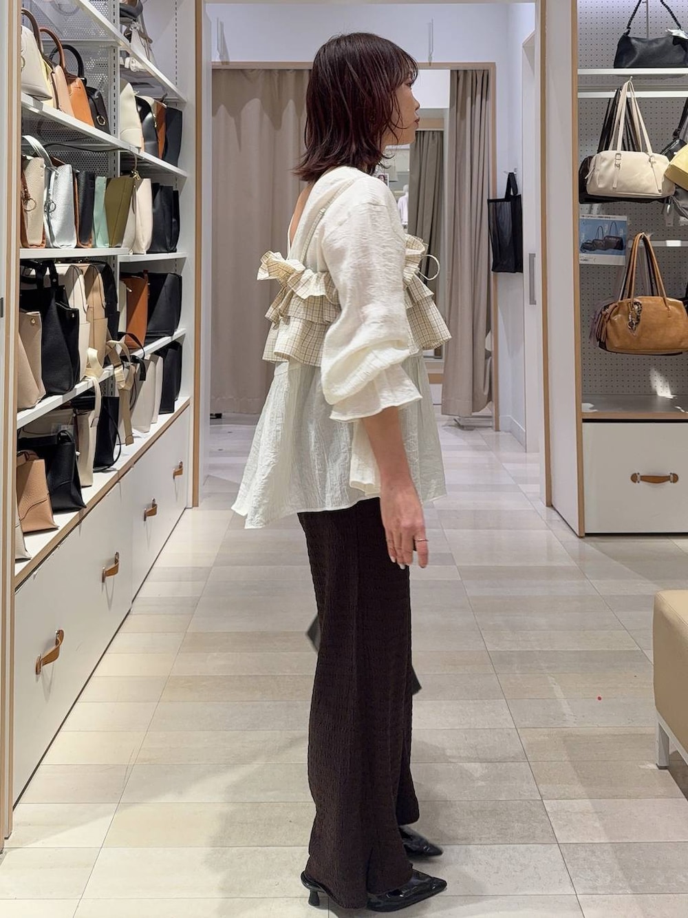 ホワイト系のブルゾン、ブラウン系のキャミソール、ブラウン系のその他パンツを着用したレディースの春コーディネートの8枚目の写真