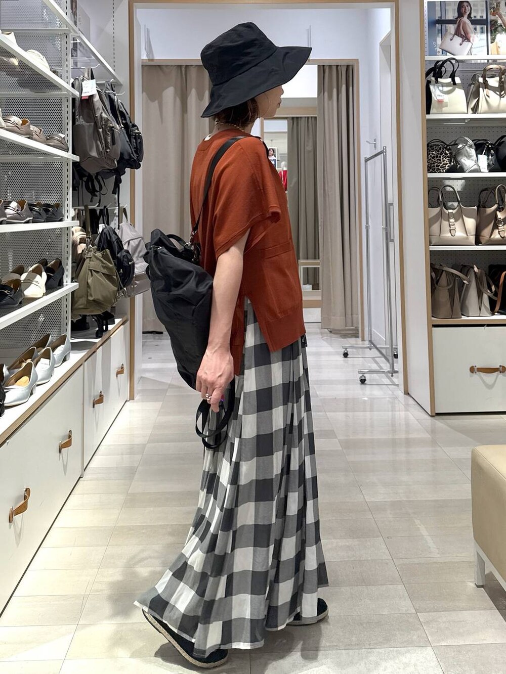 ホワイト系のスカート、ブラック系のスリッポン、オレンジ系のカーディガン/ボレロを着用したレディースの春コーディネートの4枚目の写真