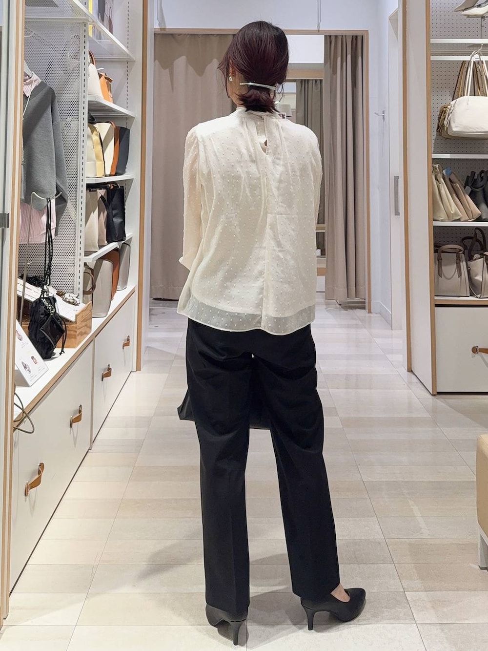 ブラック系のスラックス、ホワイト系のシャツ/ブラウス、ブラック系のその他アウターを着用したレディースの冬コーディネートの8枚目の写真