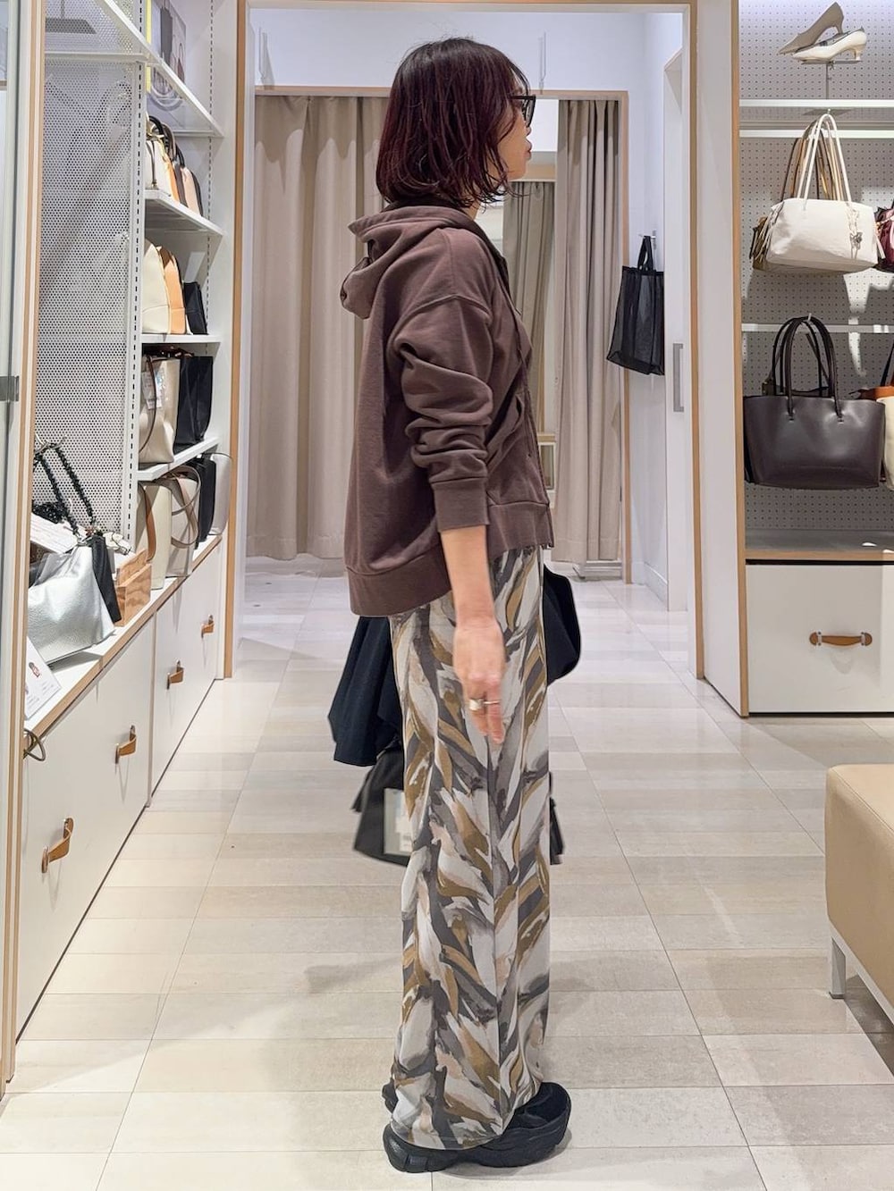 ブラック系のボストンバッグ、ブラック系のスニーカー、ブルー系のテーラードジャケットを着用したレディースの冬コーディネートの8枚目の写真