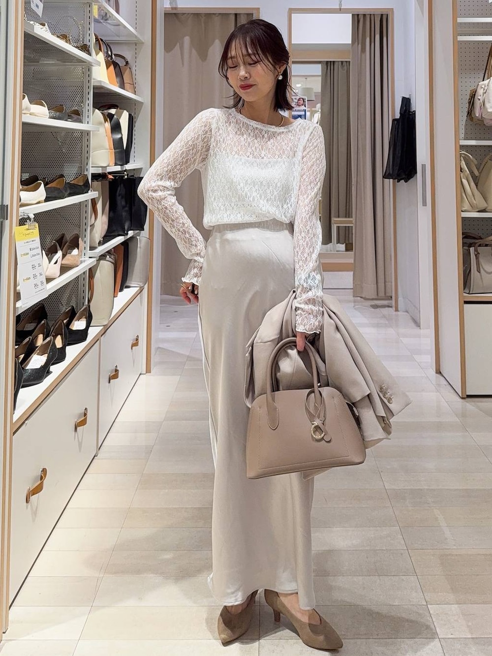 ベージュ系のショルダーバッグ、ベージュ系のパンプス、ホワイト系のキャミソールを着用したレディースの冬コーディネートの2枚目の写真