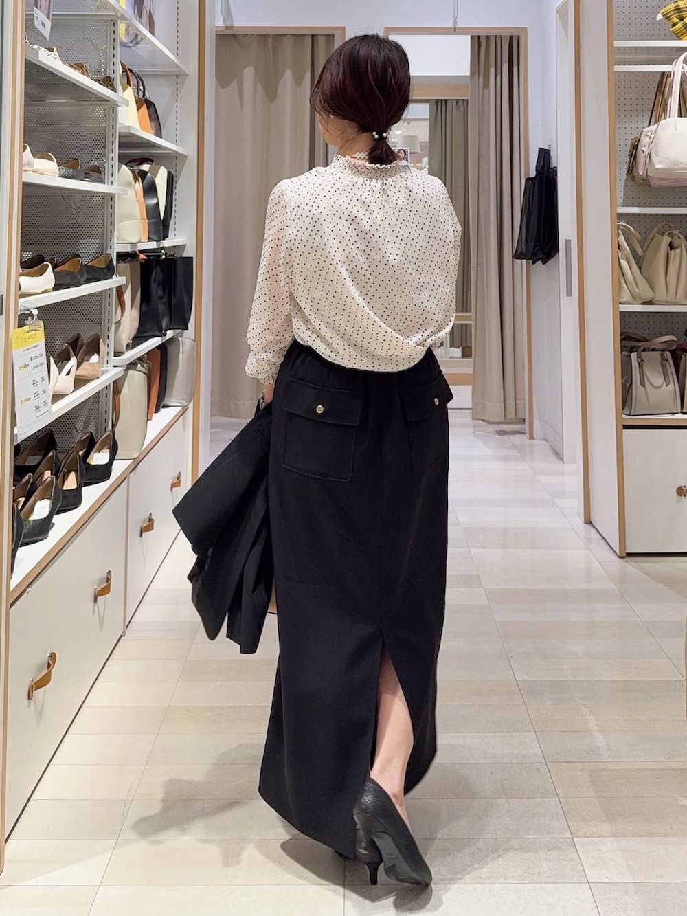 ブラック系のパンプス、ブラック系のノーカラージャケット、ベージュ系のショルダーバッグを着用したレディースの冬コーディネートの7枚目の写真