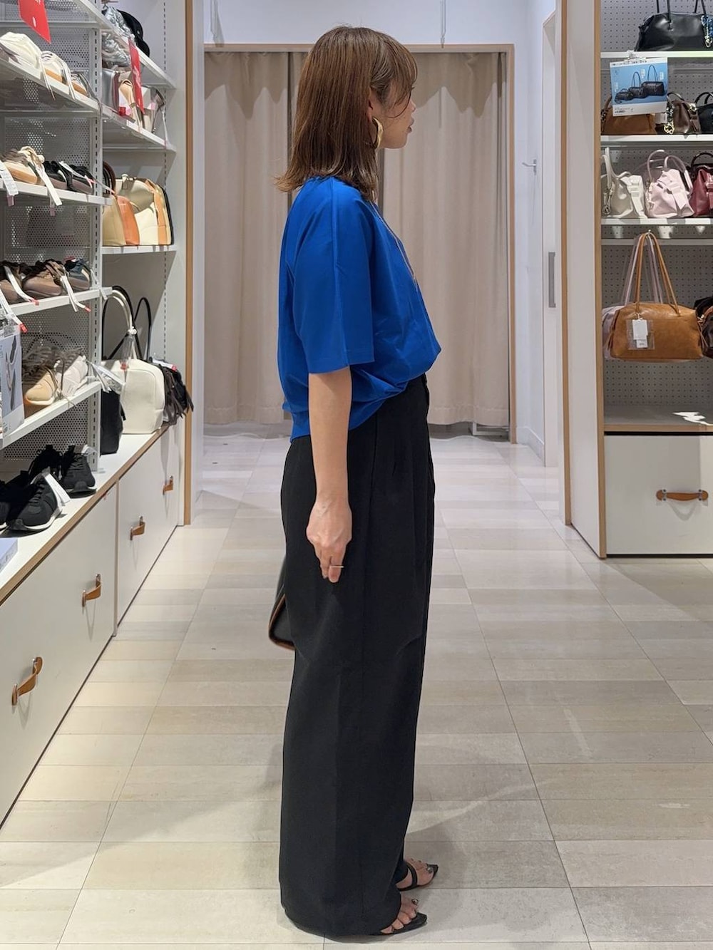 ブラック系のトートバッグ、ブラック系のその他パンツ、ブルー系のTシャツ/カットソーを着用したレディースの夏コーディネートの3枚目の写真