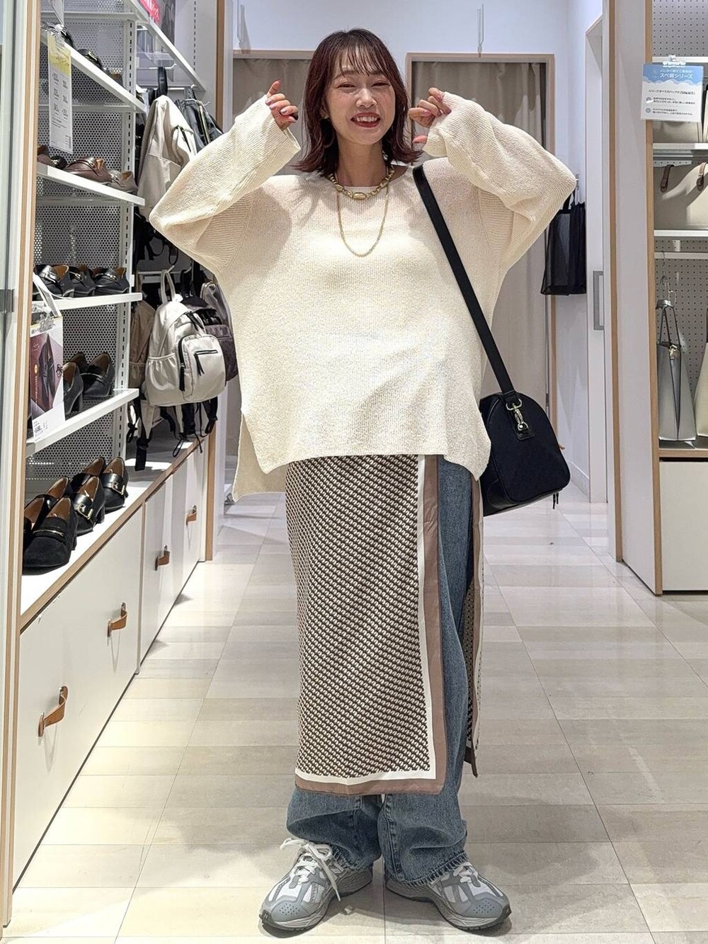 ホワイト系のキャミソール、ブルー系のデニムパンツ、ブラック系のボストンバッグを着用したレディースの秋コーディネートの4枚目の写真